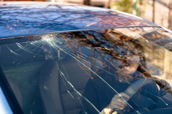 Auto Glass Replacement Rock Island IL, Shocked woman in car with broken windshield and cracks. Car accident. Selective focus